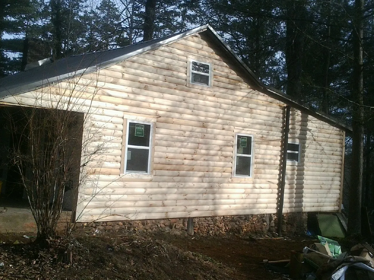 New log siding and dark metal roofing on a gable end in Sharon