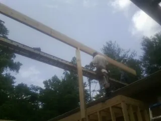 Carpenter setting a ridge beam over a new addition frame — Ice Dam Removal by Roofing Brothers in Sharon